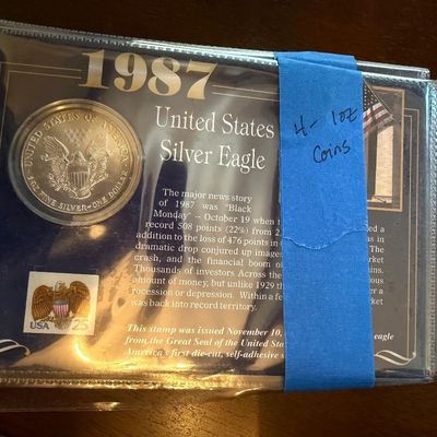 Sale Photo Thumbnail #255: 1987 United States Silver Eagle 1 oz fine silver coin presentation card packaged with a commemorative stamp.