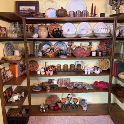 Large mid-century modern style wooden shelving unit filled with an assortment of vintage kitchenware, ceramics, glassware, and decorative...