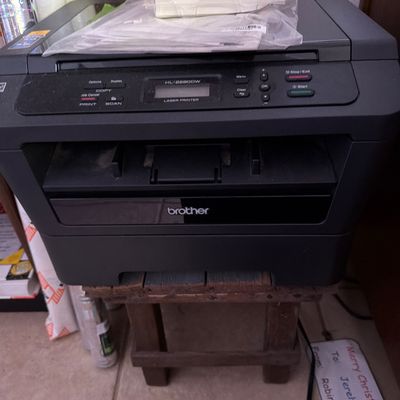 Sale Photo Thumbnail #153: Brother HL-2280DW monochrome laser printer with copy and scan functions, sitting on a small wooden stool.