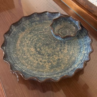 Handcrafted ceramic chip and dip platter featuring a ruffled edge and a mottled blue and tan glaze.