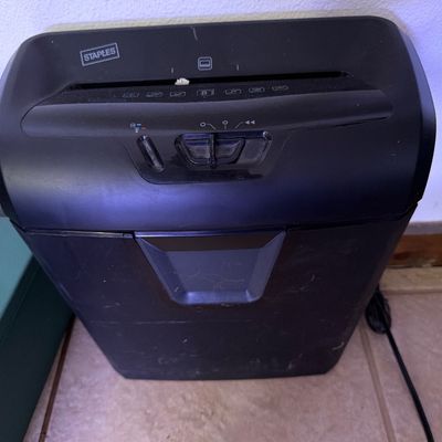 Sale Photo Thumbnail #155: Staples brand black paper shredder, showing some surface wear and dust from use.