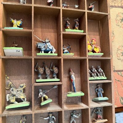 Collection of vintage hand-painted metal miniature figures, including knights, soldiers, and archers, displayed in a wooden shadow box...