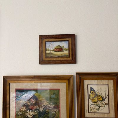 Sale Photo Thumbnail #199: Collection of three framed vintage artworks, including a small landscape painting of a red barn, a floral watercolor print, and an illustrated butterfly print, all housed in wooden frames.