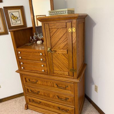 Vintage oak gentleman's chest featuring a three-drawer base, a side cabinet with diagonal wood paneling, four small drawers with...