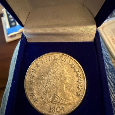 Sale Photo Thumbnail #205: Replica or novelty 1804 Draped Bust silver dollar coin, presented in a blue velvet display box.