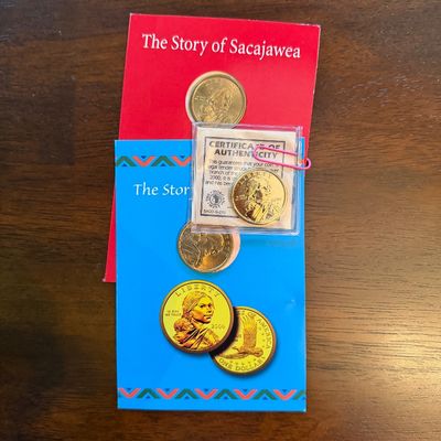 Sale Photo Thumbnail #236: Year 2000 Sacagawea golden dollar coin set, including "The Story of Sacajewea" informational booklets and a certified authentic coin in a protective sleeve.