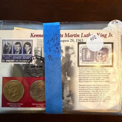 Sale Photo Thumbnail #213: Commemorative postal and coin set honoring John F. Kennedy and Martin Luther King Jr., featuring two 1994 Kennedy half dollars and international stamps.