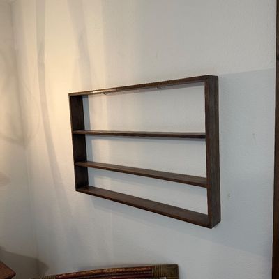 Wall-mounted dark stain wood shadow box shelf unit featuring three long horizontal display tiers.