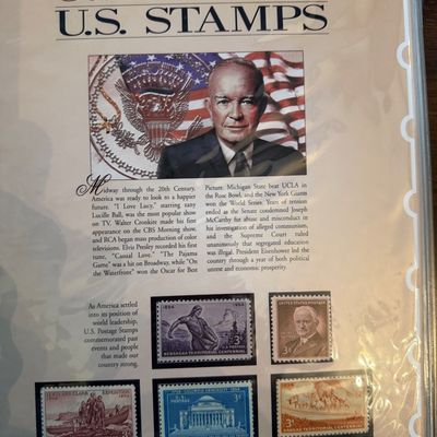 Sale Photo Thumbnail #265: "The Golden Age of Commemorative U.S. Stamps" collector's panel for the year 1954, featuring historical text, an illustration of Dwight D. Eisenhower, and five commemorative stamps in protective mounts.
