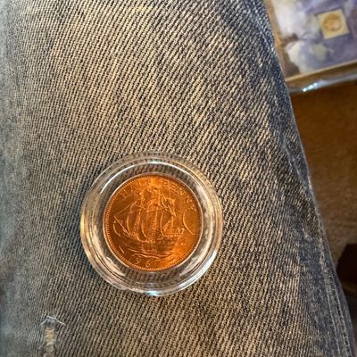 Sale Photo Thumbnail #258: British 1967 half penny coin depicting a sailing ship, encased in a round clear protective capsule.