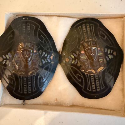 Vintage Egyptian Revival style belt buckle set featuring pharaoh motifs on dark, curved panels, presented in a white box.
