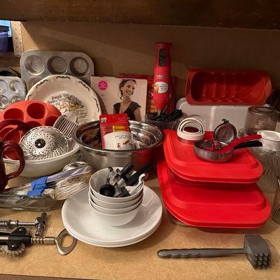 Sale Photo Thumbnail #145: Assortment of kitchenware and baking supplies, including mixing bowls, wooden spoons, a hand blender, muffin tins, and storage containers.