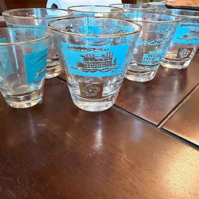 Set of vintage mid-century drinking glasses featuring turquoise and gold steamboat motifs.
