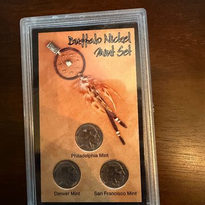 Sale Photo Thumbnail #237: Three-piece Buffalo Nickel Mint Set featuring coins from the Philadelphia, Denver, and San Francisco mints, housed in a protective plastic display case with a dreamcatcher motif.