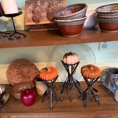 Sale Photo Thumbnail #124: Collection of rustic home decor including studio pottery bowls and mugs, wrought iron pumpkin stands, candle holders, and a pewter tankard.