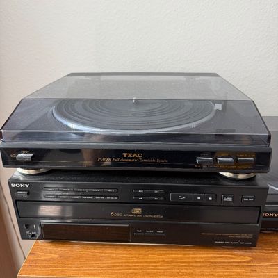 TEAC P-A688 full-automatic turntable system with built-in phono equalizer amplifier, stacked on top of a Sony 5-disc automatic disc...