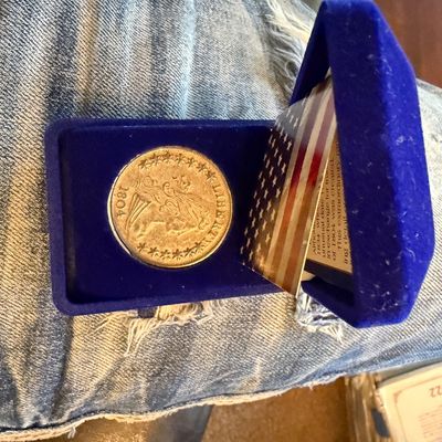 Sale Photo Thumbnail #204: Replica 1804 Draped Bust silver dollar coin, housed in a blue velvet presentation case with an American flag insert.