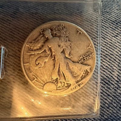 Sale Photo Thumbnail #207: United States Walking Liberty half dollar coin dated 1942, housed in a protective plastic sleeve.
