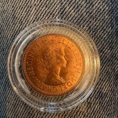 Sale Photo Thumbnail #256: British Queen Elizabeth II copper coin, housed in a protective clear plastic capsule.