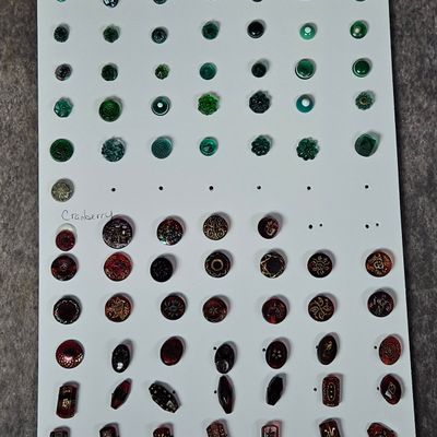 A Collection of Czech Glass Buttons in Cranberry and Green Paperweight Styles