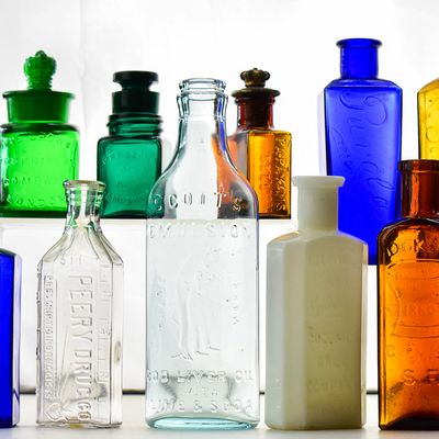 NINE ASSORTED PHARMACY AND COSMETIC BOTTLES: THE CROWN PERFUMERY, PEERY, AND MORE