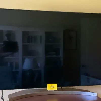 Sale Photo Thumbnail #14: LG curved smart television on a matching curved stand, showing a reflective dark screen.