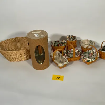 Sale Photo Thumbnail #20: Collection of Longaberger miniature baskets with floral fabric liners, accompanied by a large woven wicker basket and a boxed set of wooden utensils.
