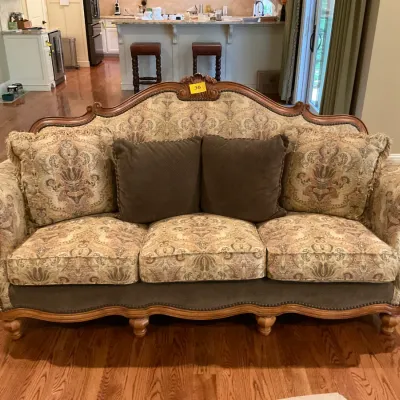 Sale Photo Thumbnail #13: Traditional camelback sofa featuring ornate carved wood trim, damask patterned upholstery, and coordinating throw pillows.