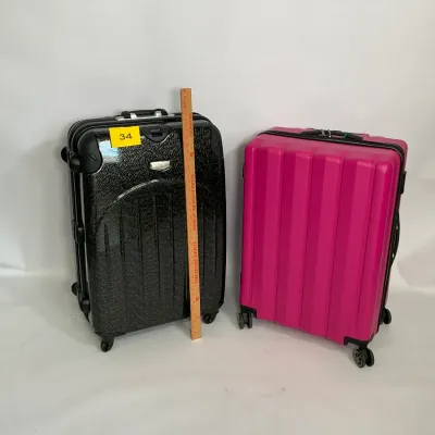 Sale Photo Thumbnail #11: Two hardside spinner suitcases, one in textured black and one in vibrant pink, both featuring multi-directional wheels and telescoping handles.