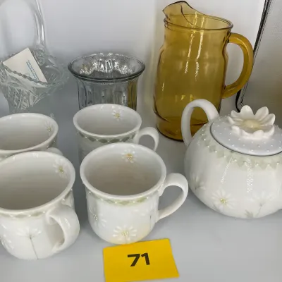 Sale Photo Thumbnail #19: Assorted glassware and ceramic tea set, including an amber glass pitcher, a clear cut-glass basket, and a white ceramic teapot with four matching daisy-patterned mugs.