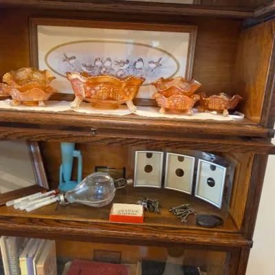 Sale Photo Thumbnail #6: Vintage oak barrister bookcase displaying a collection of marigold carnival glass bowls, picture frames, and small collectibles.