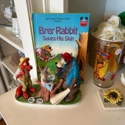 Sale Photo Thumbnail #133: Vintage Disney Br'er Rabbit, Br'er Fox, and Br'er Bear ceramic figurine, displayed alongside a "Br'er Rabbit Saves His Skin" book. 