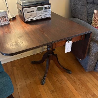 Sale Photo Thumbnail #38: Vintage Duncan Phyfe style mahogany drop-leaf table with a single drawer and brass claw feet. 