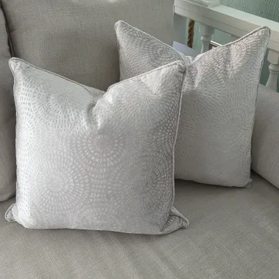 Sale Photo Thumbnail #31: Pair of light gray plush throw pillows featuring a subtle, geometric circular motif and piped edges.