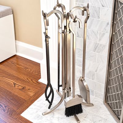 Sale Photo Thumbnail #135: Contemporary brushed nickel fireplace tool set with stand, including a shovel, broom, poker, and tongs.
