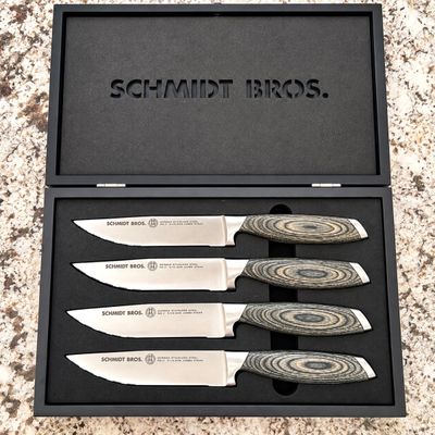 Sale Photo Thumbnail #134: Set of four Schmidt Bros. German stainless steel jumbo steak knives featuring pakkawood handles, housed in a original fitted black wooden display box.