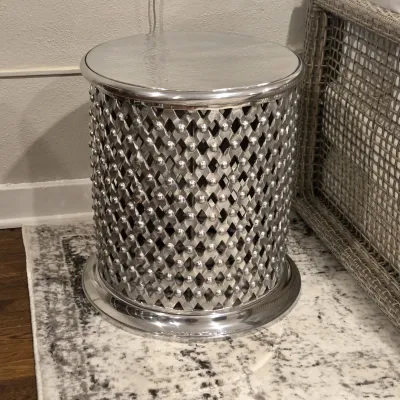 Sale Photo Thumbnail #53: Contemporary polished silver metal drum side table featuring a hammered top and an openwork diamond-lattice base with raised stud details.