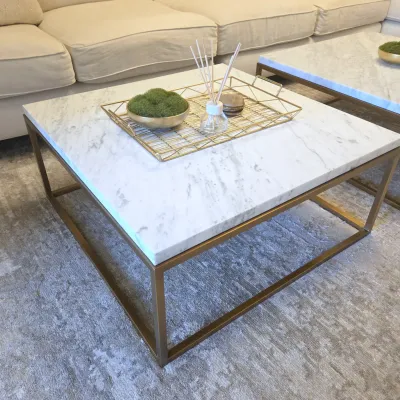 Sale Photo Thumbnail #114: Restoration Hardware Contemporary square coffee table featuring a white marble top set in a brushed brass-finished metal frame. Shown staged with decorative accents alongside a matching sofa and rug.