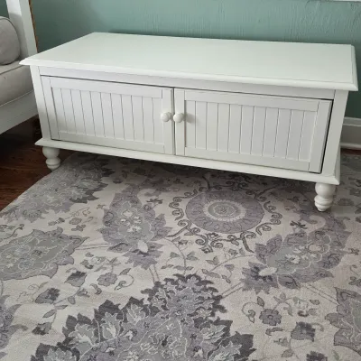 Sale Photo Thumbnail #28: White painted cottage-style low cabinet with beadboard panel doors, turned feet, and matching white knobs.