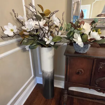 Sale Photo Thumbnail #36: Tall modern ombre floor vase with artificial magnolia branches alongside a tabletop floral arrangement on a wooden buffet.