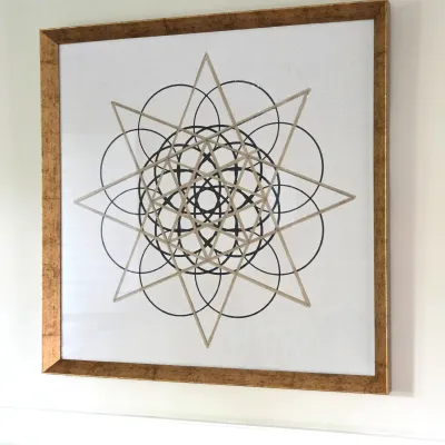 Sale Photo Thumbnail #126: Framed contemporary wall art featuring a geometric sacred mandala print, presented in a square gilt frame.