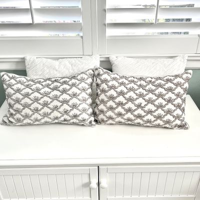 Sale Photo Thumbnail #137: Pair of rectangular white throw pillows with silver beaded scalloped patterns, accompanied by two white textured accent pillows.