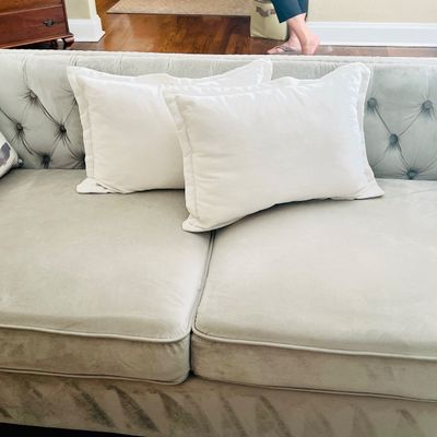 Sale Photo Thumbnail #21: Tufted light gray velvet sofa featuring a button-backed frame, piped seat cushions, and two matching throw pillows.
