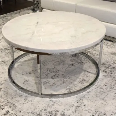 Sale Photo Thumbnail #61: Modern round coffee table featuring a polished white marble top and a polished chrome metal frame, resting on a contemporary patterned rug.