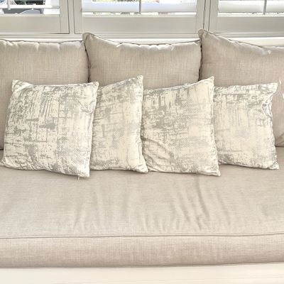 Sale Photo Thumbnail #9: Contemporary beige upholstered sofa featuring a three-cushion back and four matching patterned accent pillows.
