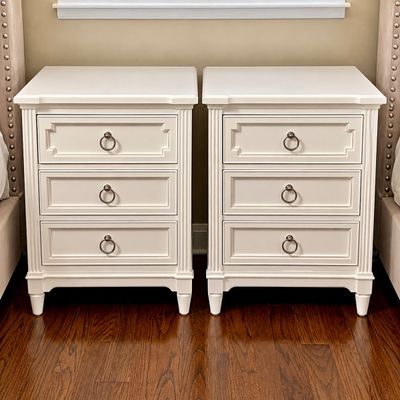 Sale Photo Thumbnail #89: Pair of off-white modern traditional nightstands featuring three drawers each with decorative molded trim and bronze ring pulls.