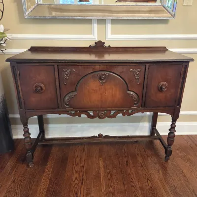 Sale Photo Thumbnail #39: Antique Jacobean Revival dark wood sideboard featuring decorative wood applique details and turned legs.