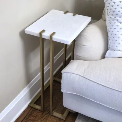 Sale Photo Thumbnail #117: Modern C-shaped end table featuring a white marble top supported by a brass-finished metal frame.