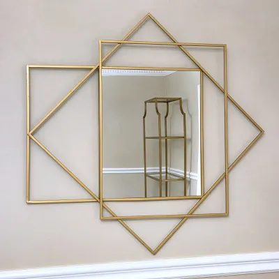 Sale Photo Thumbnail #118: Modern wall mirror featuring a central rectangular mirror surrounded by an asymmetrical geometric frame in a matte gold finish.