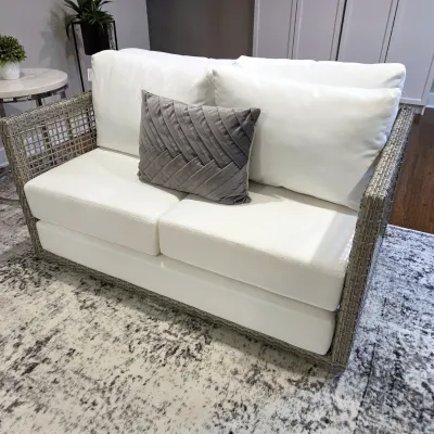 Sale Photo Thumbnail #57: Contemporary woven rattan outdoor or indoor loveseat featuring thick white seat and back cushions and a grey textured accent pillow.